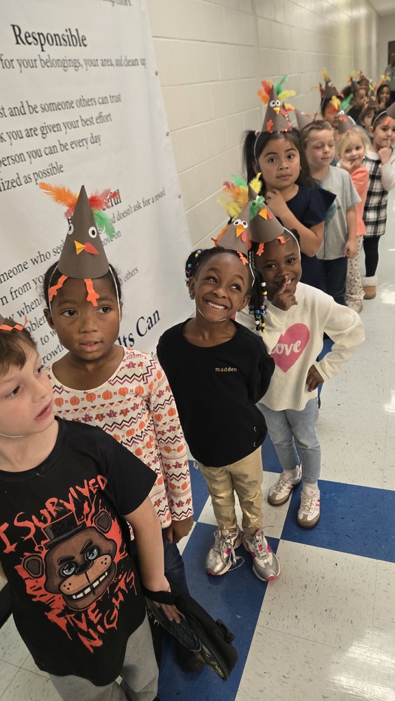 kids in hall lined up, wearing turkey hats