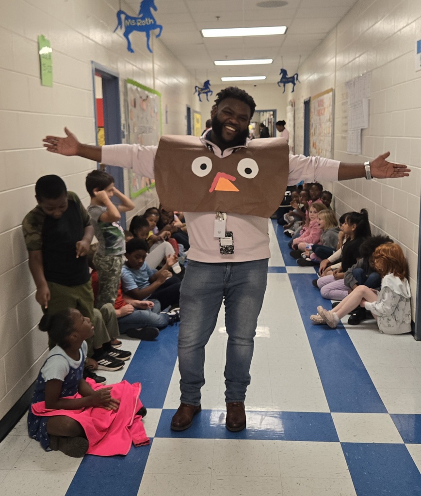 man in turkey outfit in hall with students sitting 