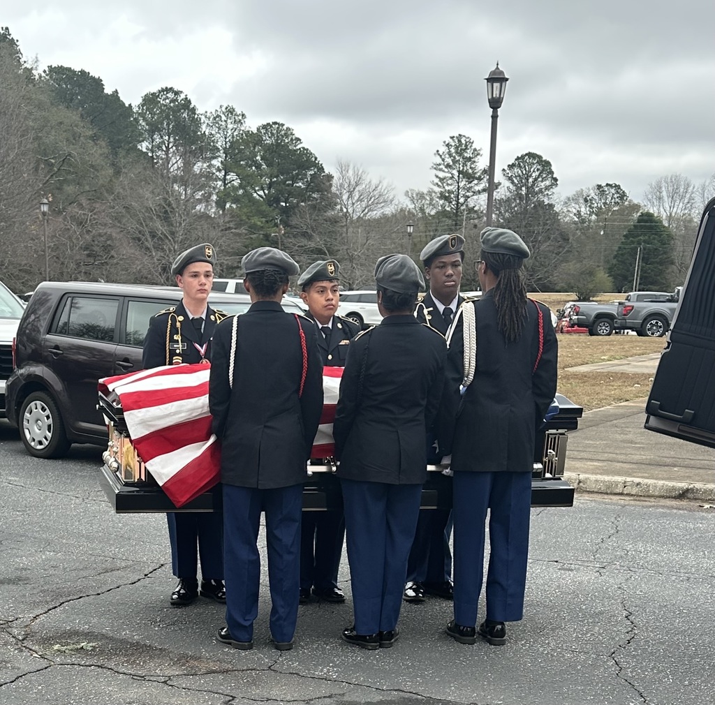 Cadets stand holding flag-draped coffin