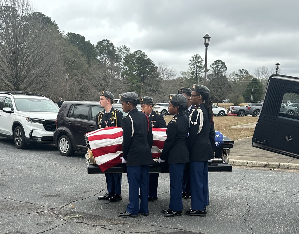 ROTC students carry a flag-draped coffin out of a hearse
