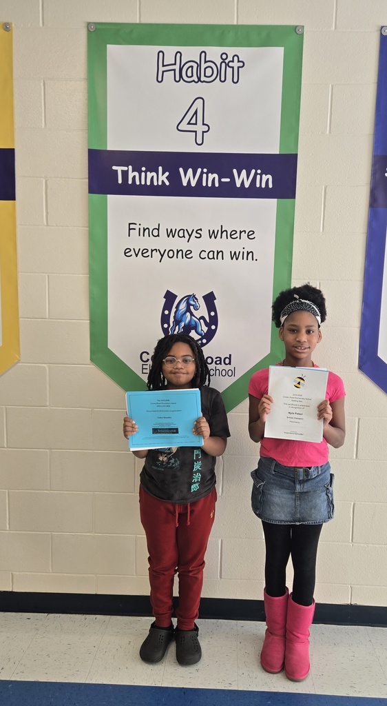 two students in hall holding certificates