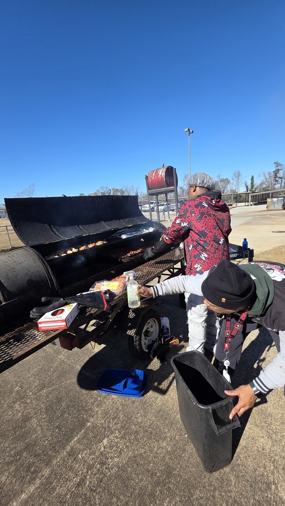 Student adds wood to a smoker