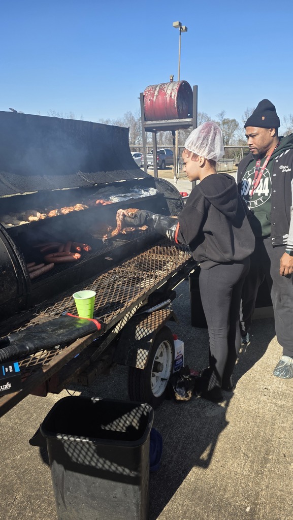 A student in a hair net smokes meat