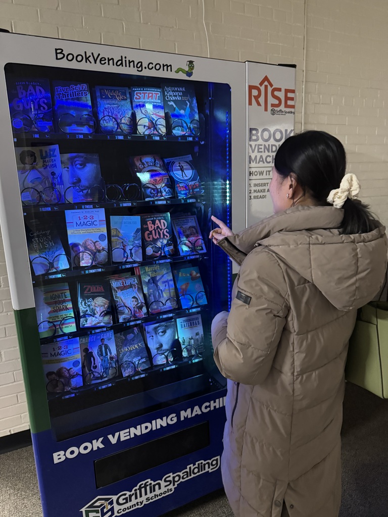 child at book vending machine
