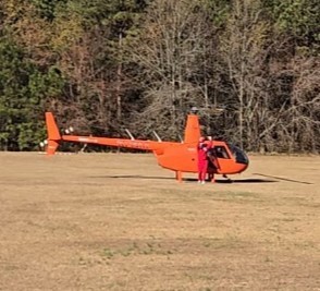 helicopter in field with elf beside