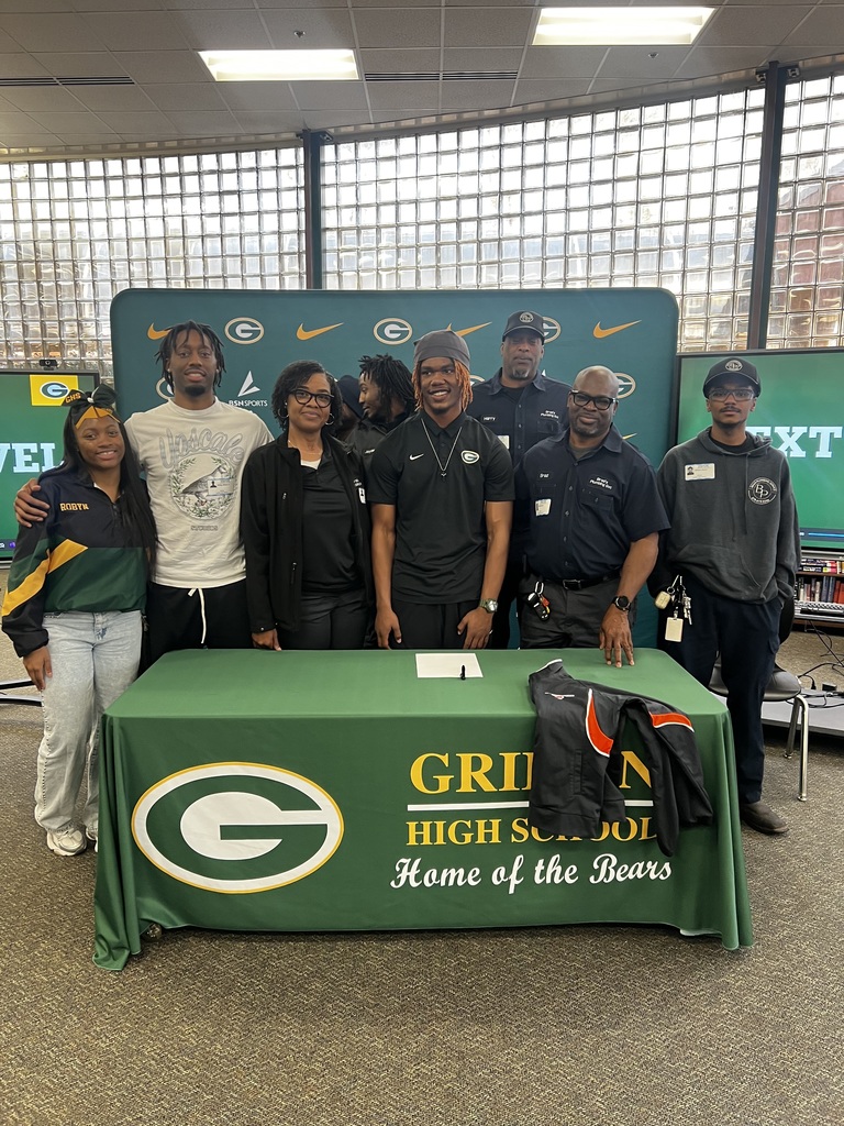 Students and family pose in front of screen with Griffin High logo