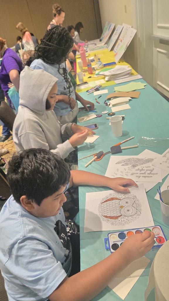 students at tables creating book themed crafts