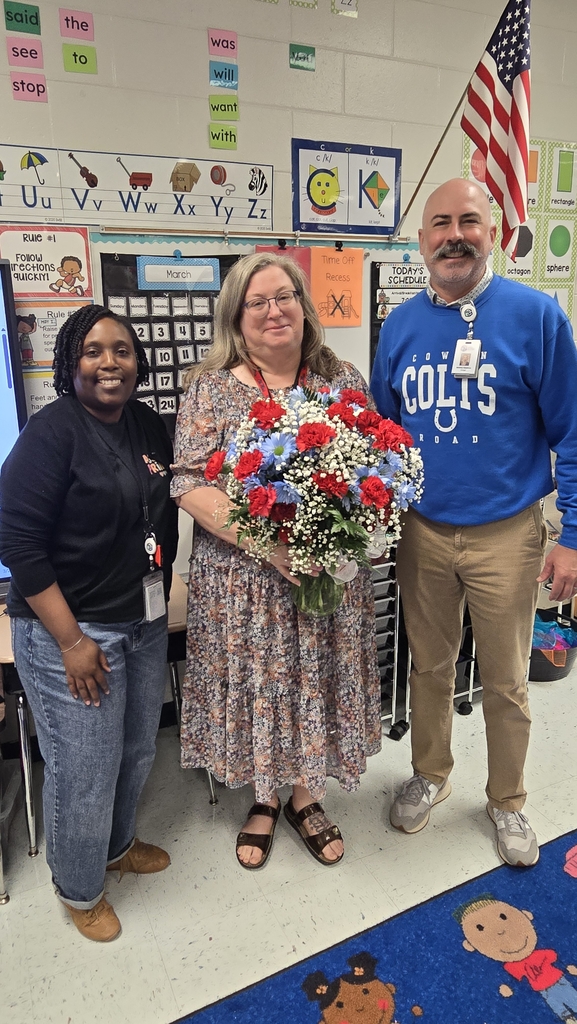 woman holding flowers with man and woman in each side of her