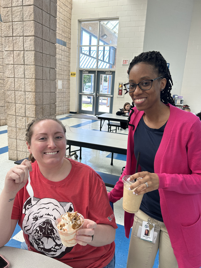 two women in cafeteria holding ice cream/drinks