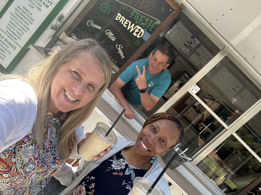 two women in front of coffee truck (with man leaning in from truck window)