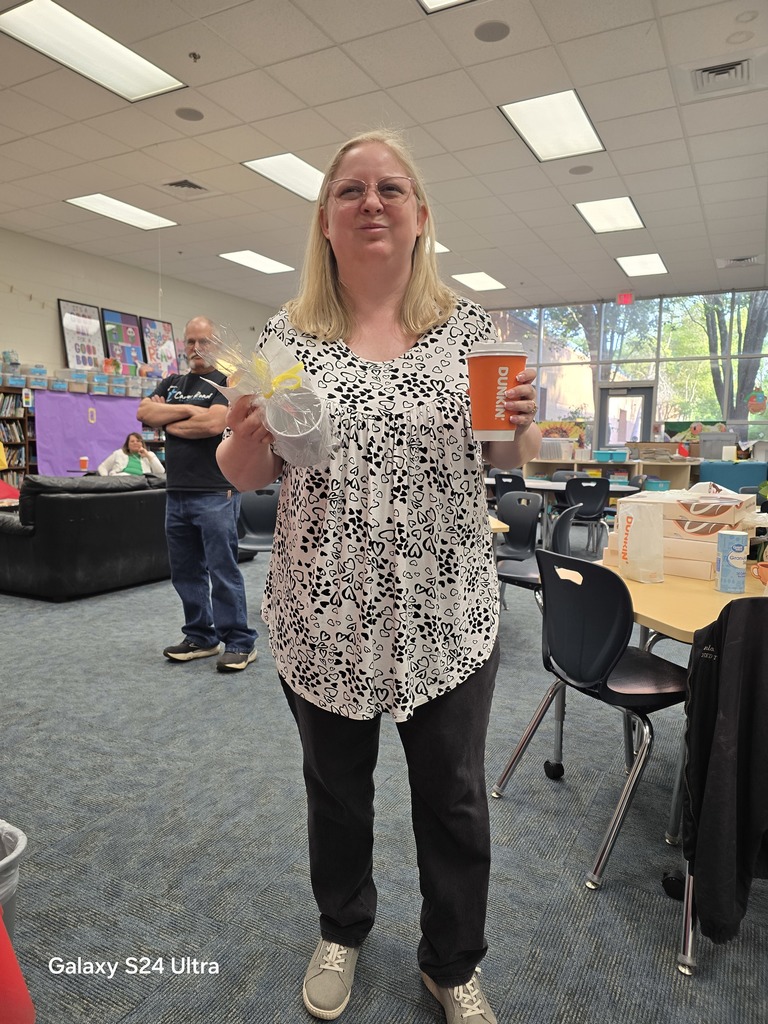 teacher holding wrapped coffee cup and cup of coffee