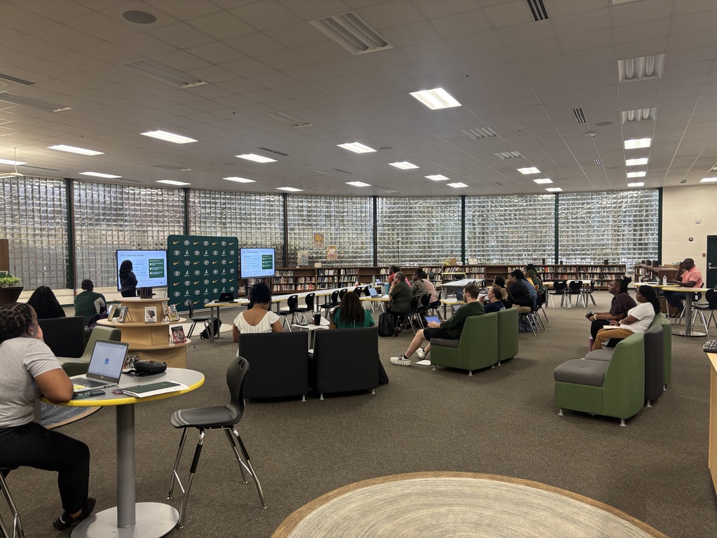 Teachers attend a meeting in the school library