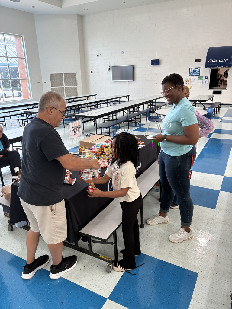 adults and children picking up snacks