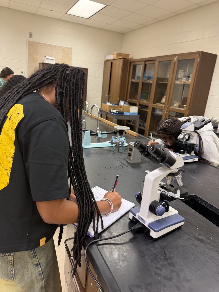 A student takes notes on her microscope observations