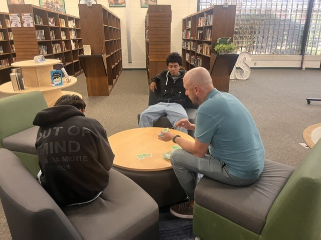 Students and a teacher play a card game