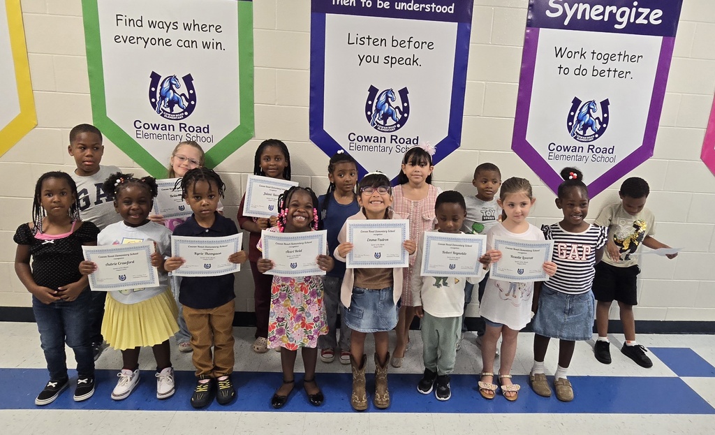 students holding certificates in the hall