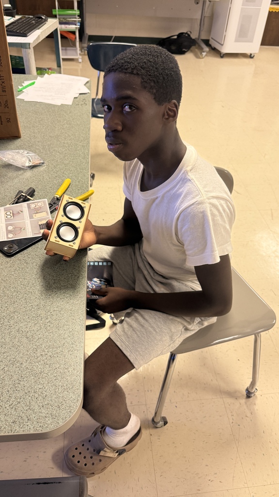 A student shows off his partially built speaker