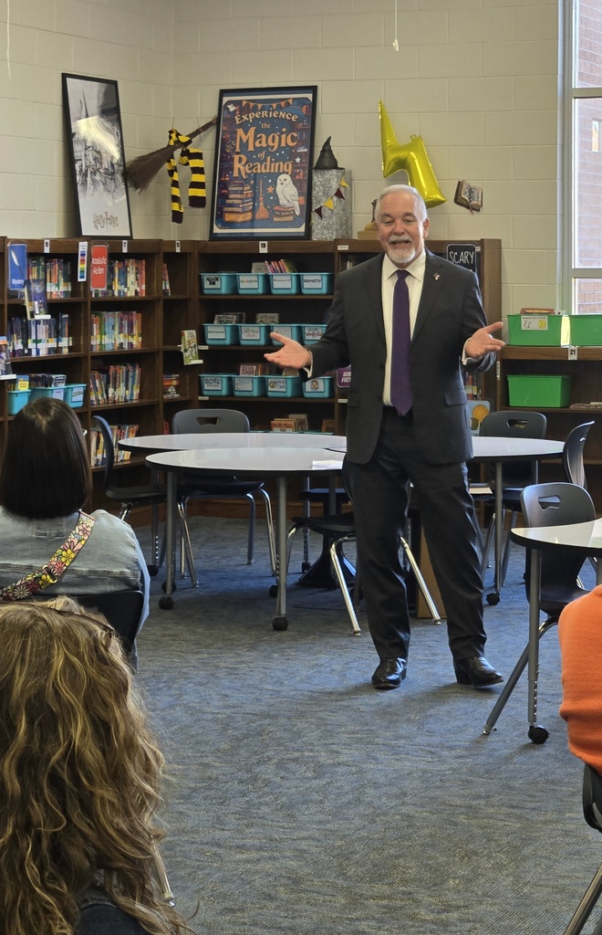 Georgia State School Superintendent Richard Woods speaking with open hands in a school library.