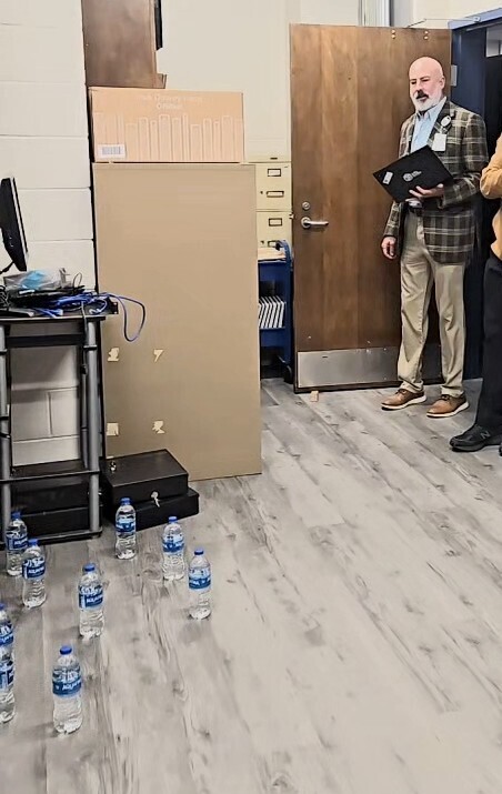 man stares at water bottles on floor