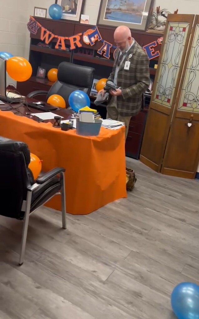man looks at office decorated in orange and blue