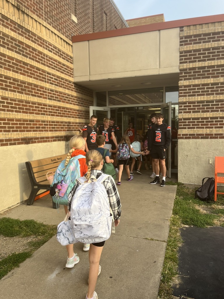 Football players giving high fives to Davis students.