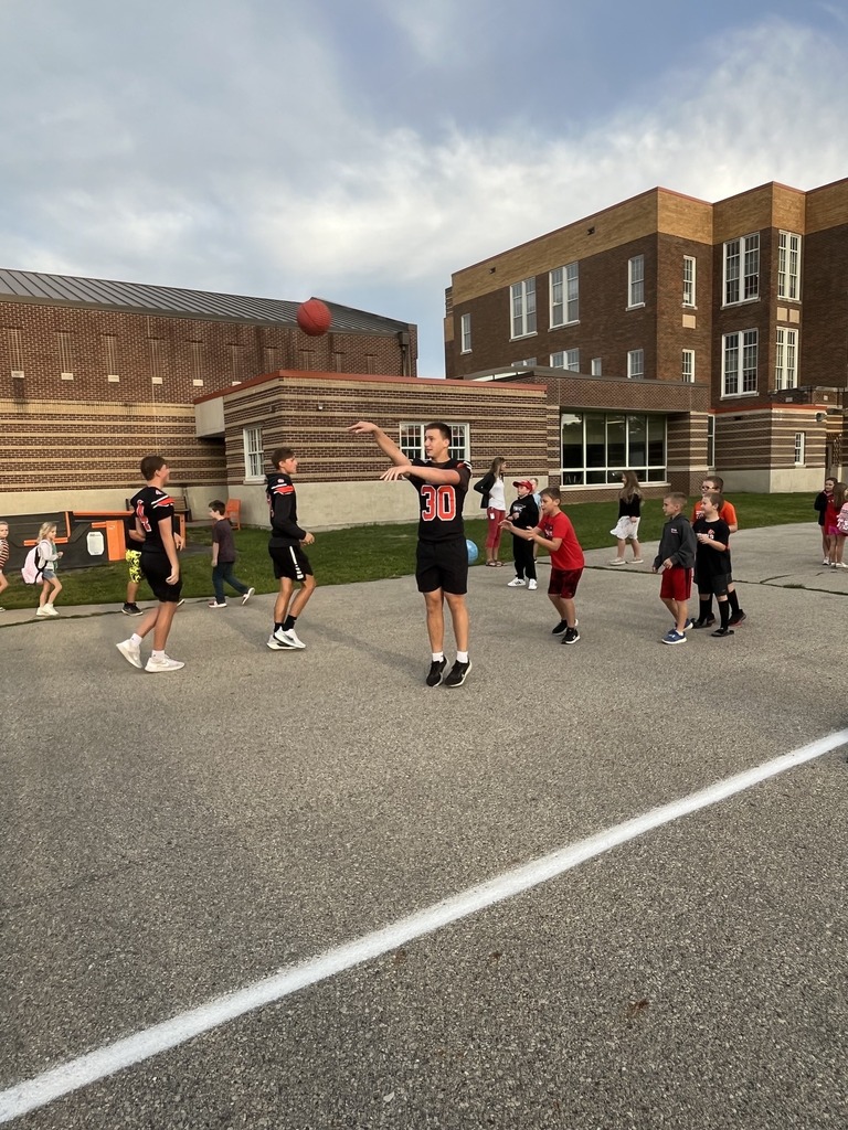 Football players giving high fives to Davis students.