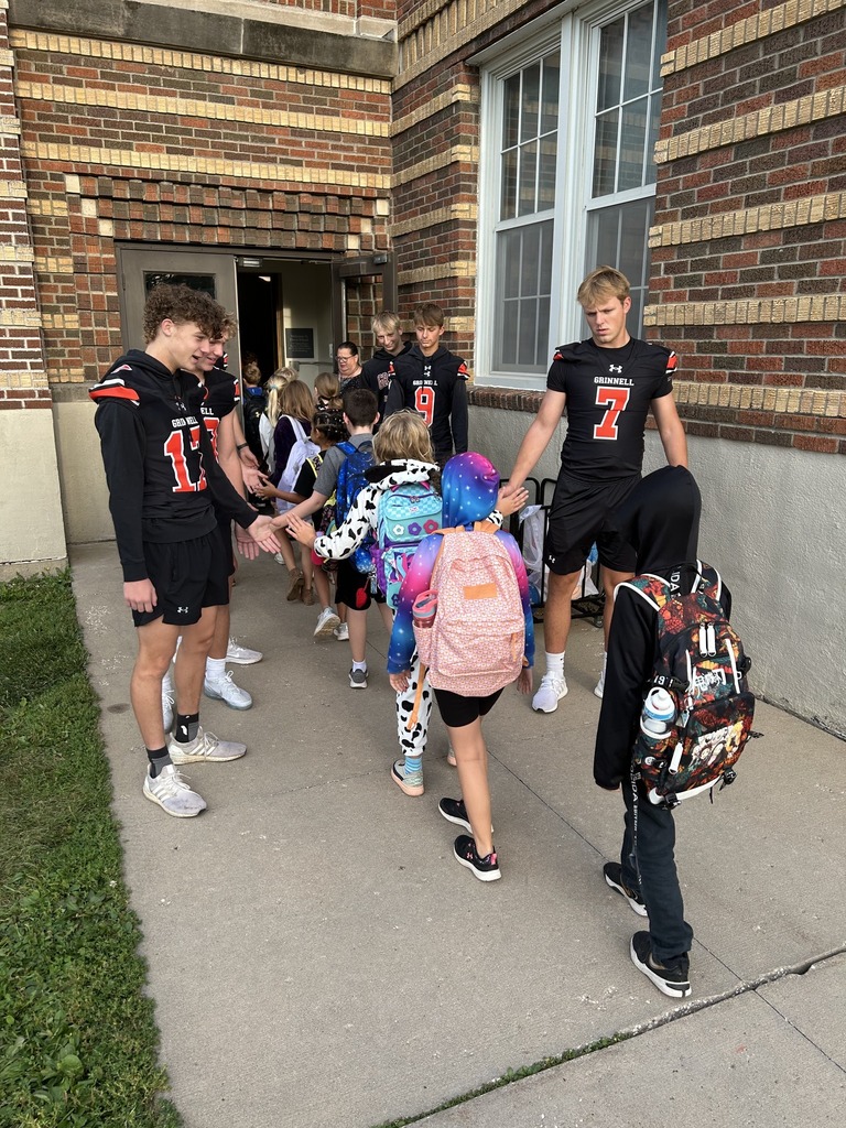 Football players giving high fives to Davis students.