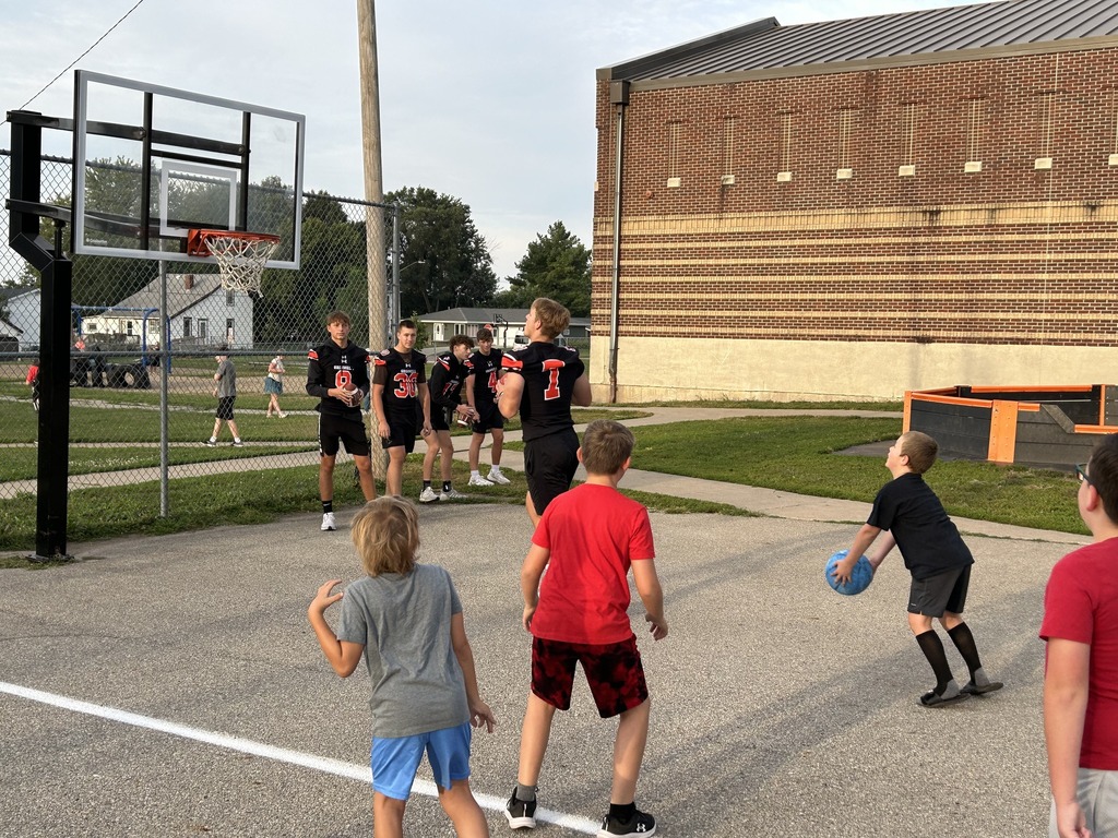Football players giving high fives to Davis students.