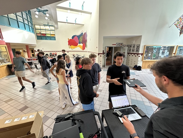 Mr. Bisbee. hands out a chromebook