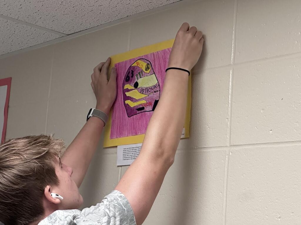 student hangs artwork