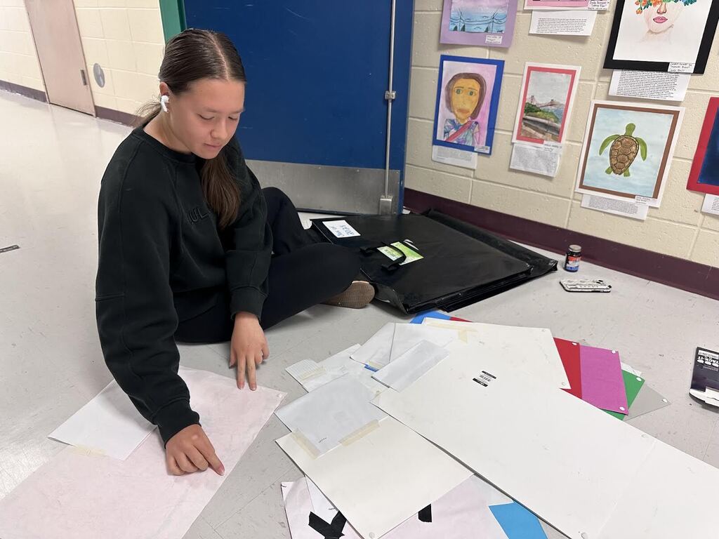 student prepares artwork to be placed