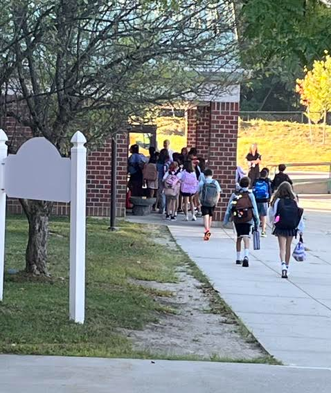 Photo of students filing into the building on the first day of school