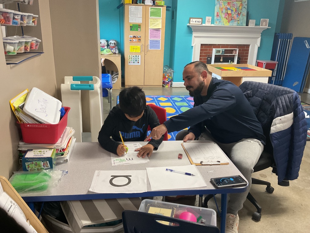 A teacher teaching a student to write.