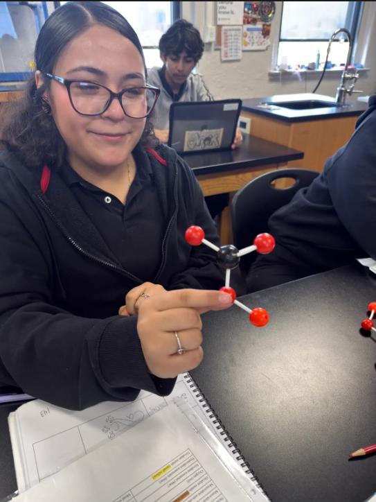 student holding a model molecule
