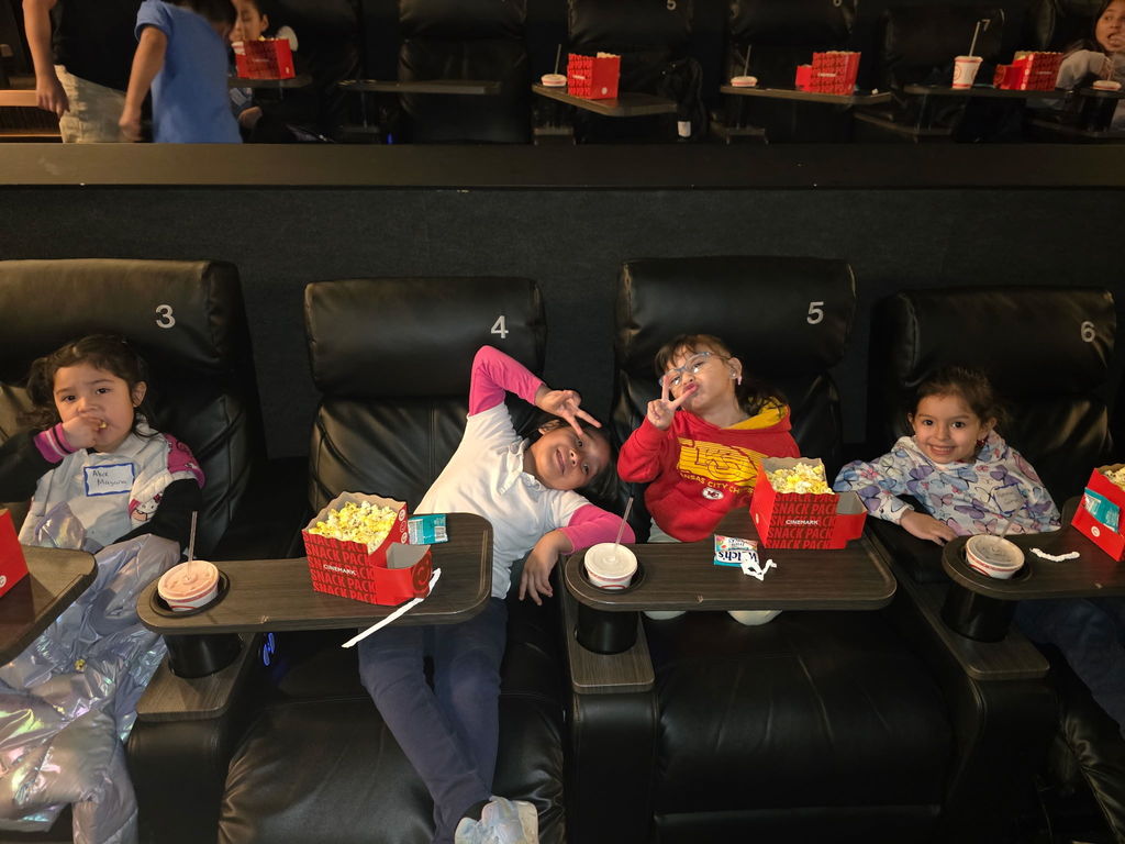 "Children sitting, waiting for the movie to start at the cinema.