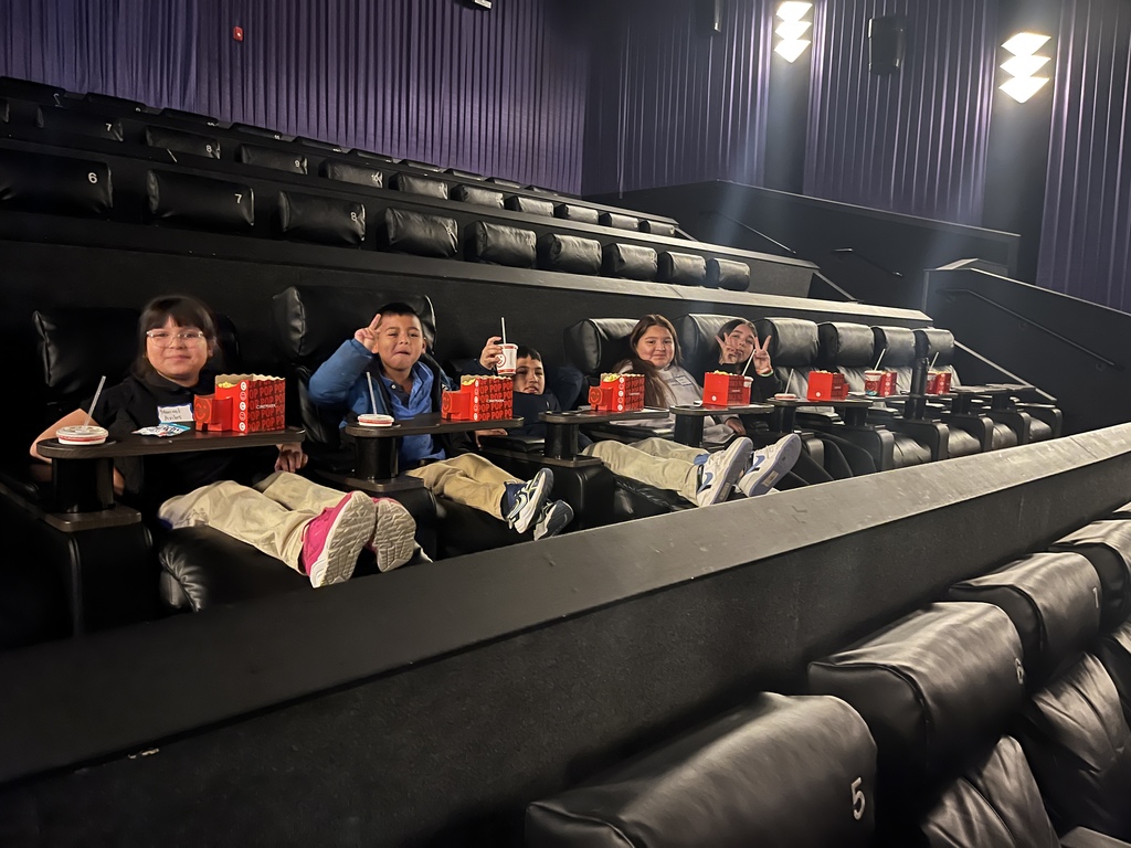 "Children sitting, waiting for the movie to start at the cinema.