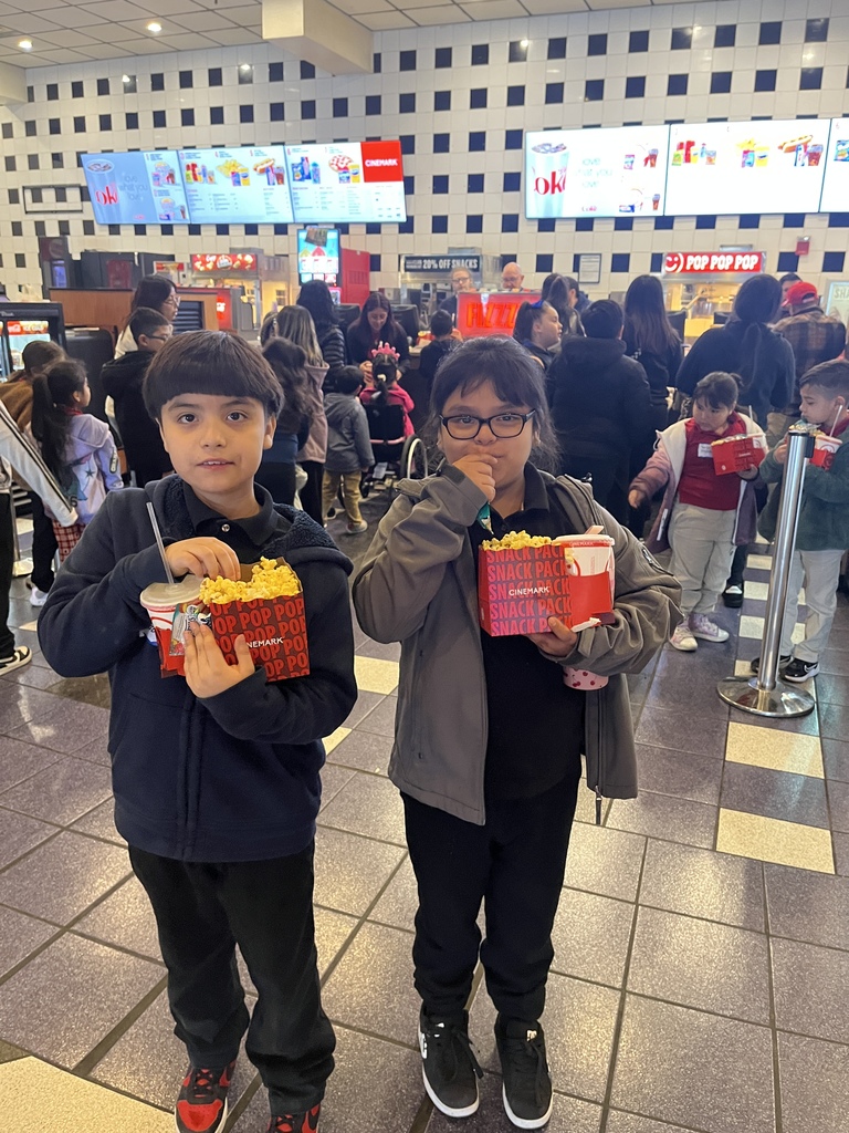 Boy and girl ready with their popcorn combo to watch a movie at the cinema