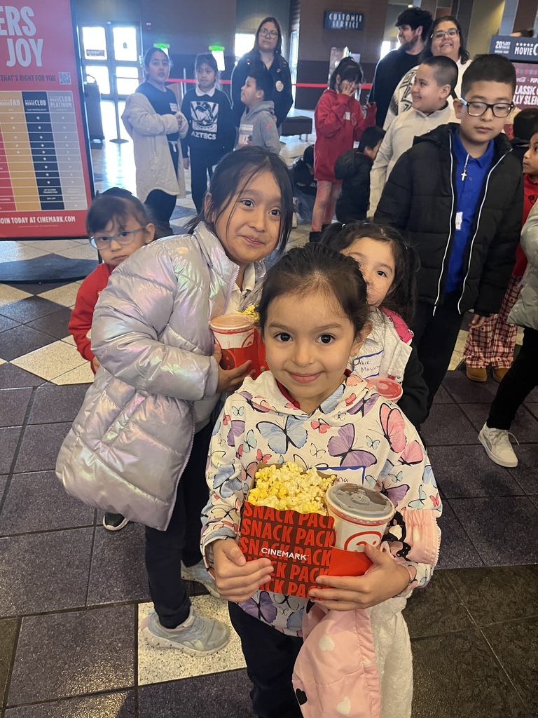 Pre-K girls waiting to go in and watch the movie at the cinema.