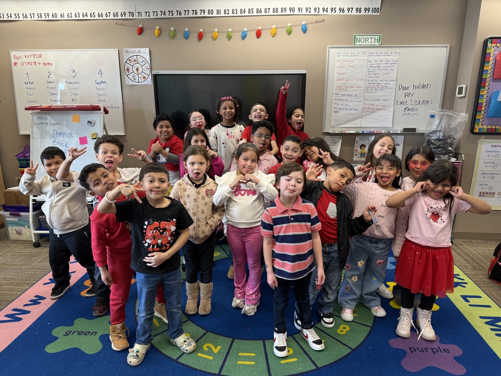 First grade group celebrating the Friendship Party dressed in pink and red