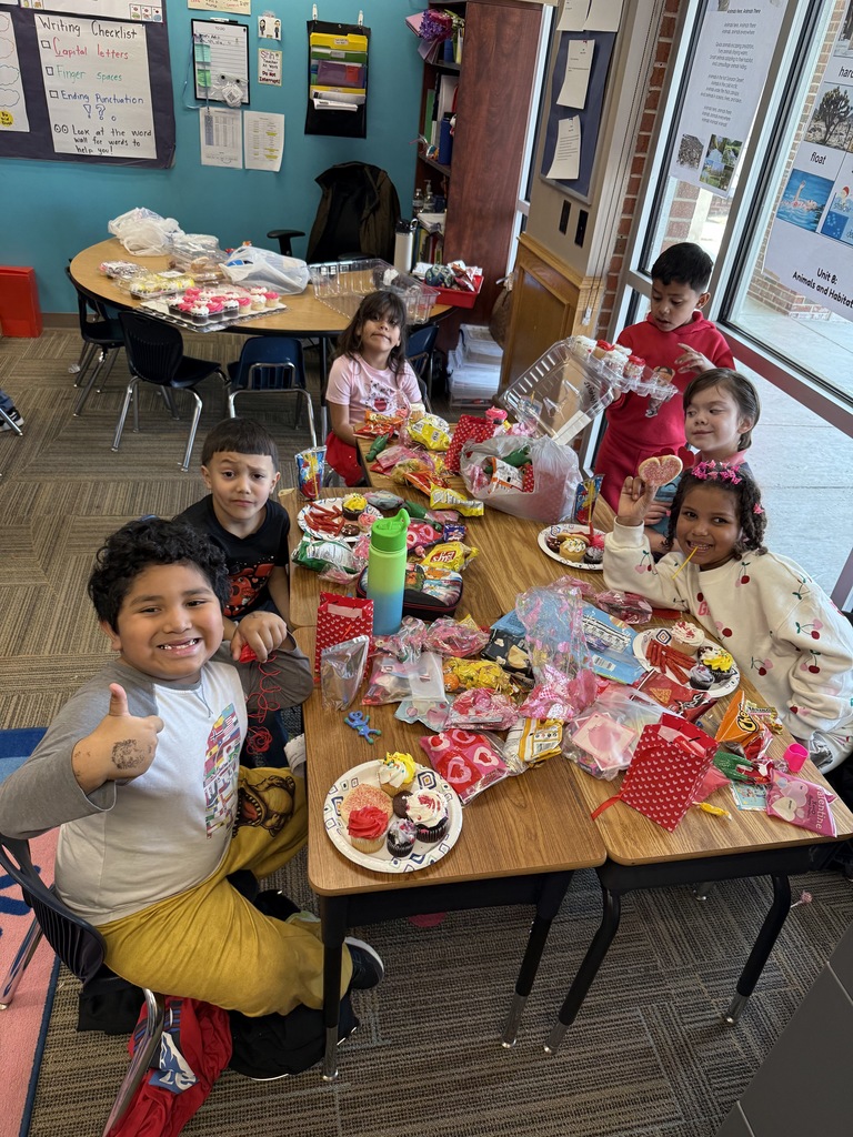 First grade group celebrating the Friendship Party dressed in pink and red