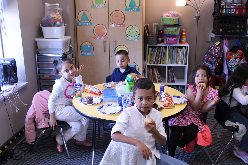 Kindergarten children enjoying cupcakes at their Friendship Celebration in their classroom