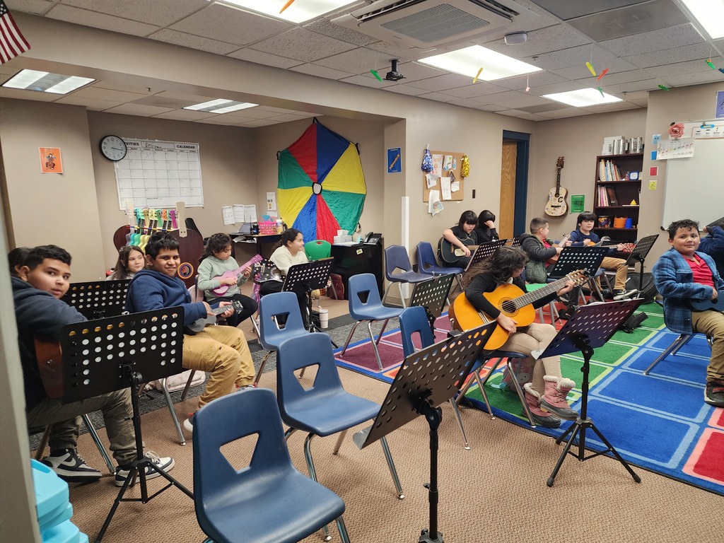 The Strings Club practicing how to play the guitar.