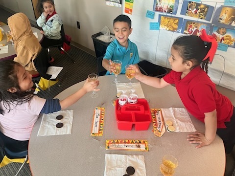 Kindergarten children making a toast with their classmates as part of a royalty-themed activity
