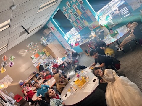Kindergarten children making a toast with their classmates as part of a royalty-themed activity