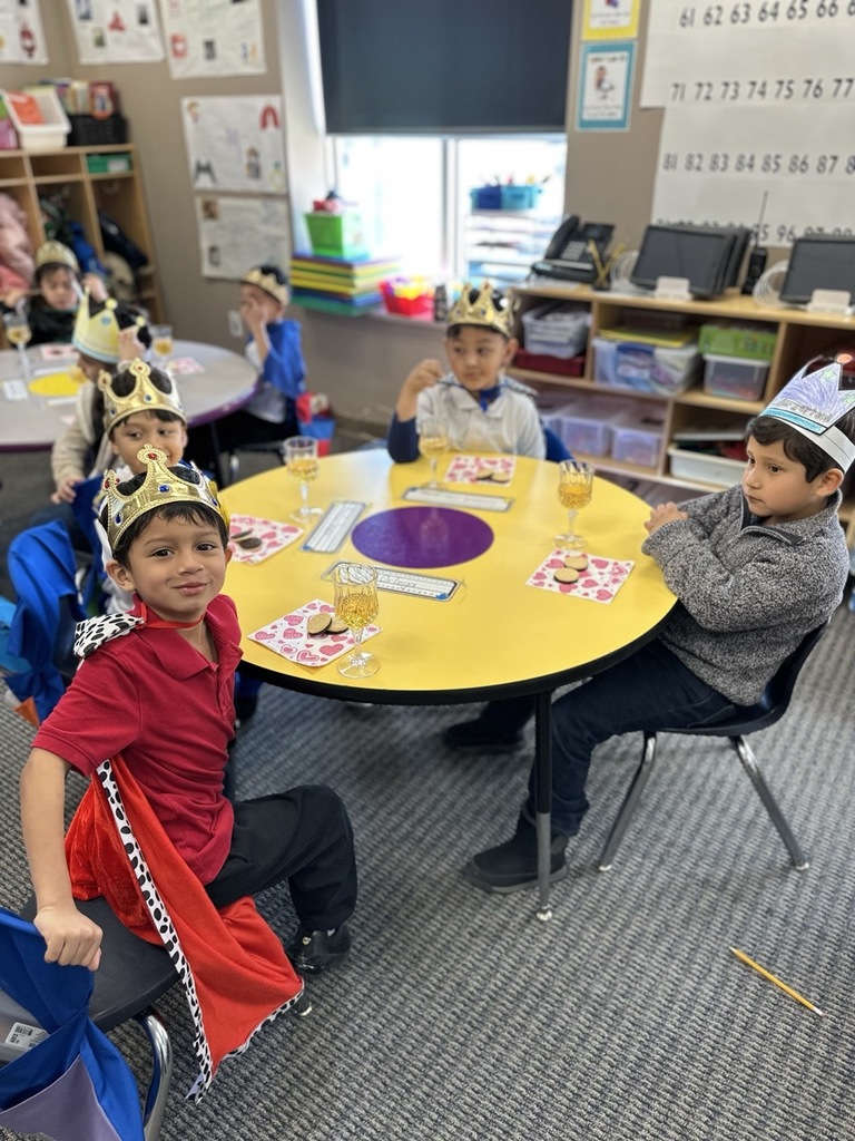 Kindergarten children making a toast with their classmates as part of a royalty-themed activity
