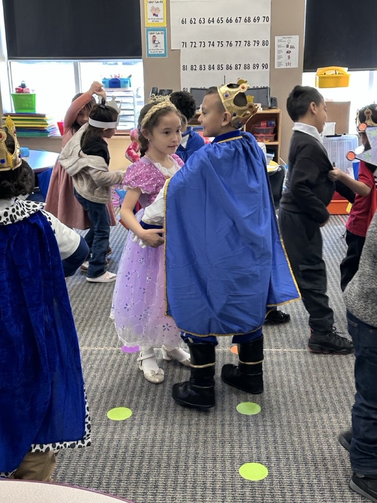 Kindergarten children dancing in pairs to a waltz, doing a classroom activity about royalty