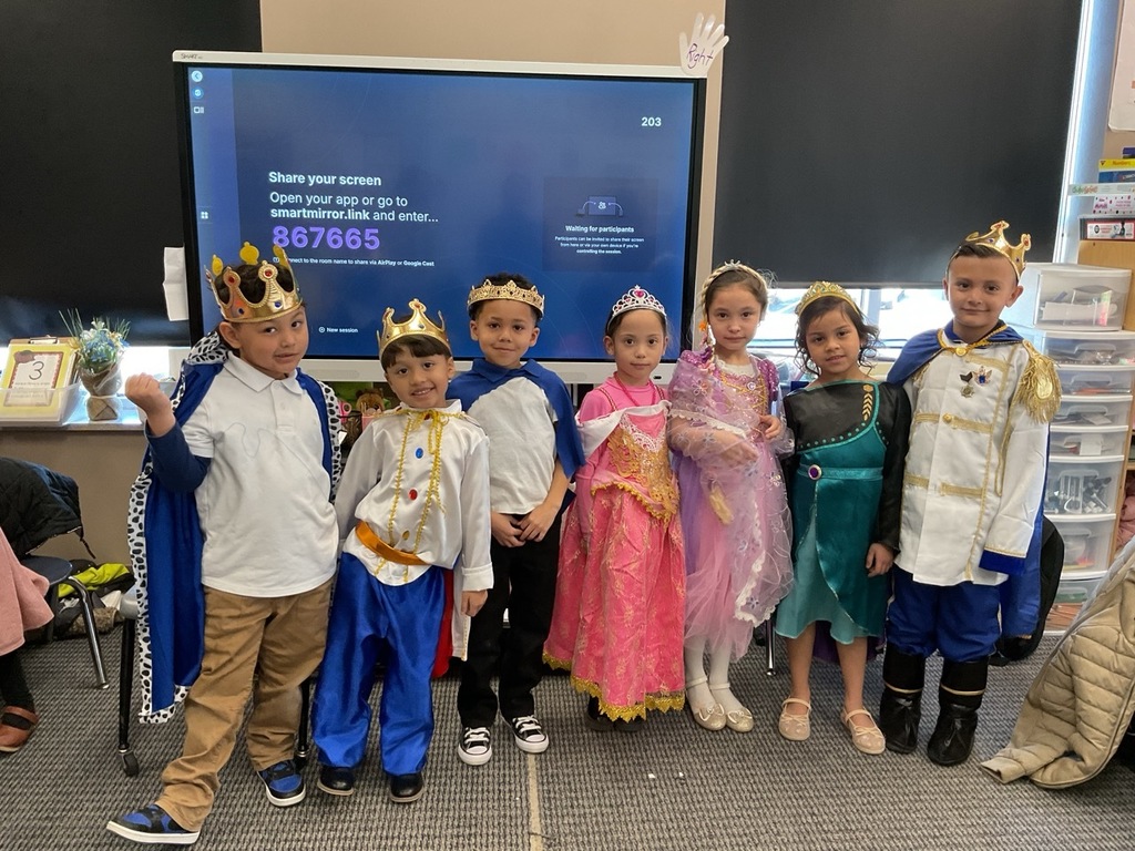 Kindergarten children dressed as queens and kings posing for a photo.