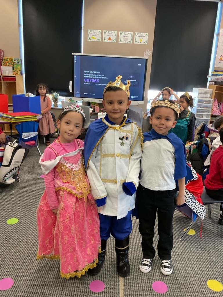 Kindergarten children dressed as queens and kings posing for a photo.
