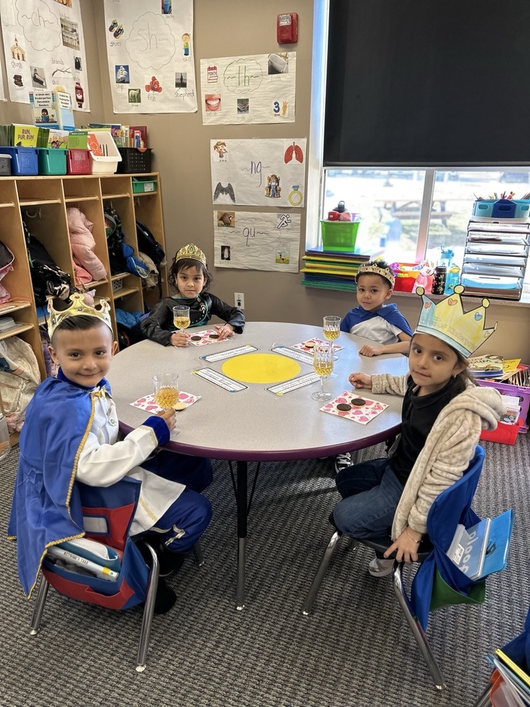 Kindergarten children making a toast with their classmates as part of a royalty-themed activity