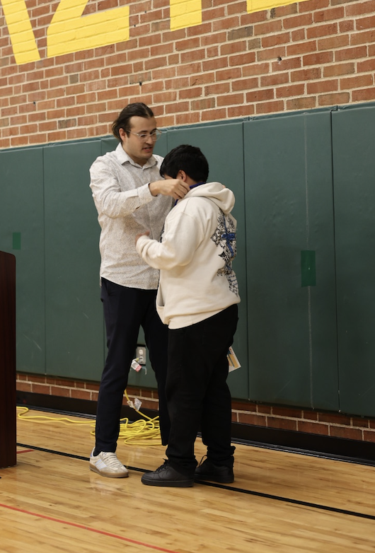 Mr. Cota giving a medal to a student